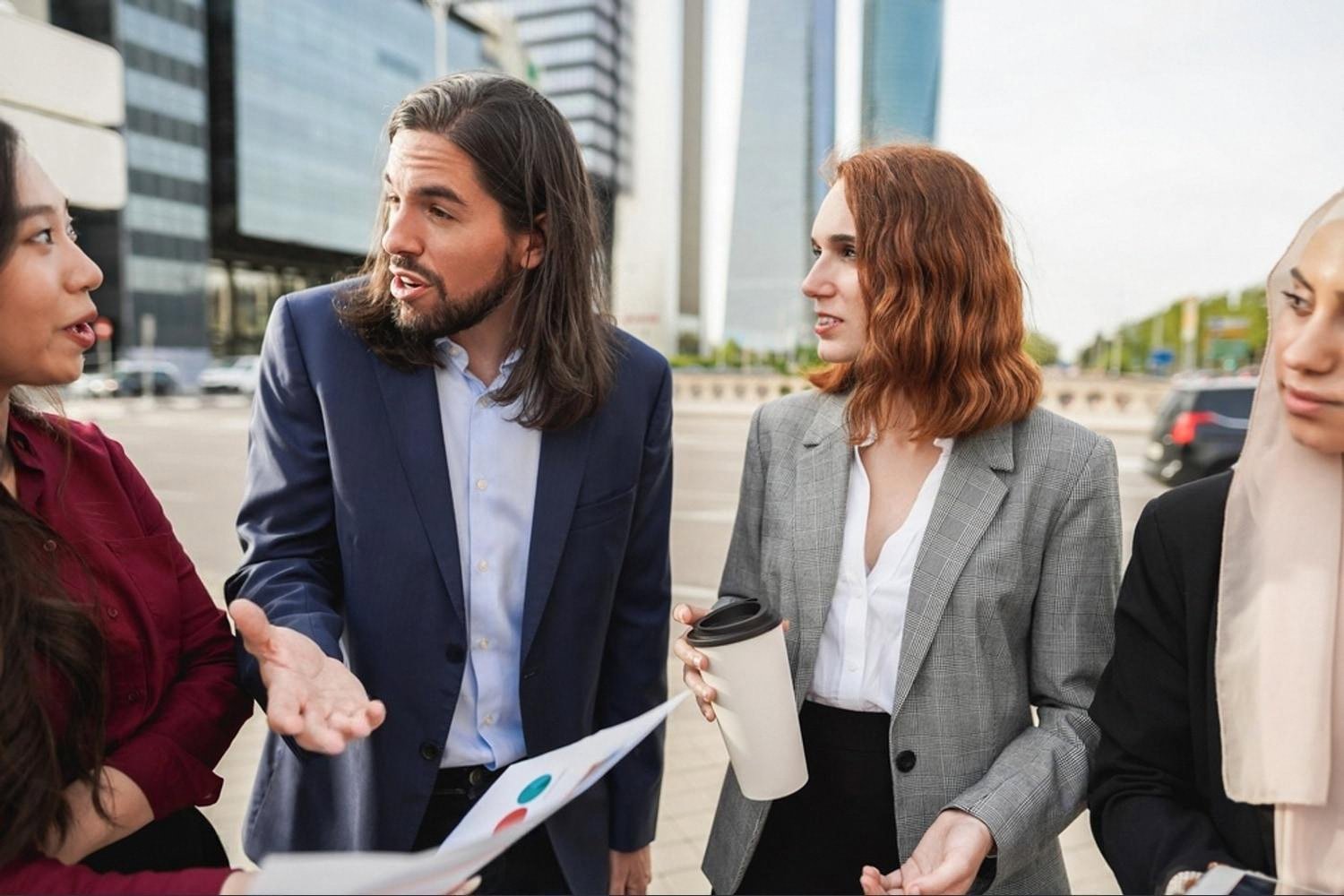 Group of colleagues in business attire having an informal conversation to help a new hire adapt